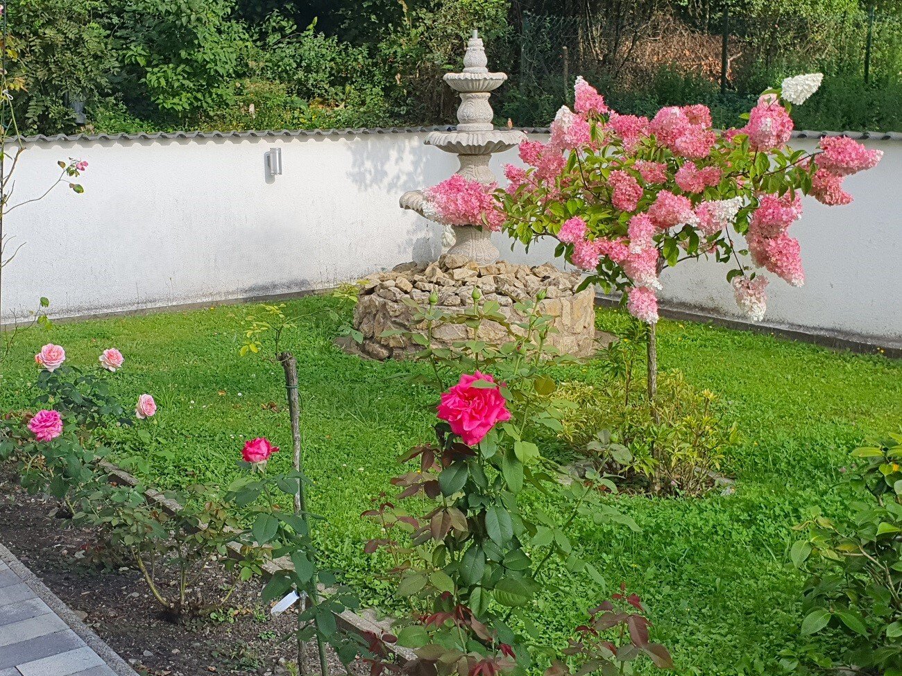 Garten neben dem Haus mit Brunnen 
