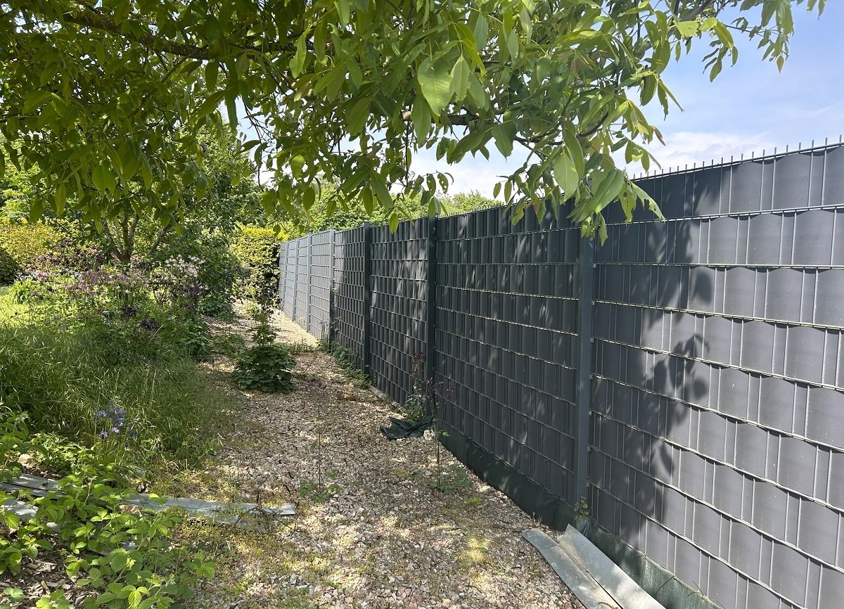 Grundstück vollständig mit Zaun und Hecke umschlossen Grundstück vollständig mit Zaun und Hecke umschlossen
